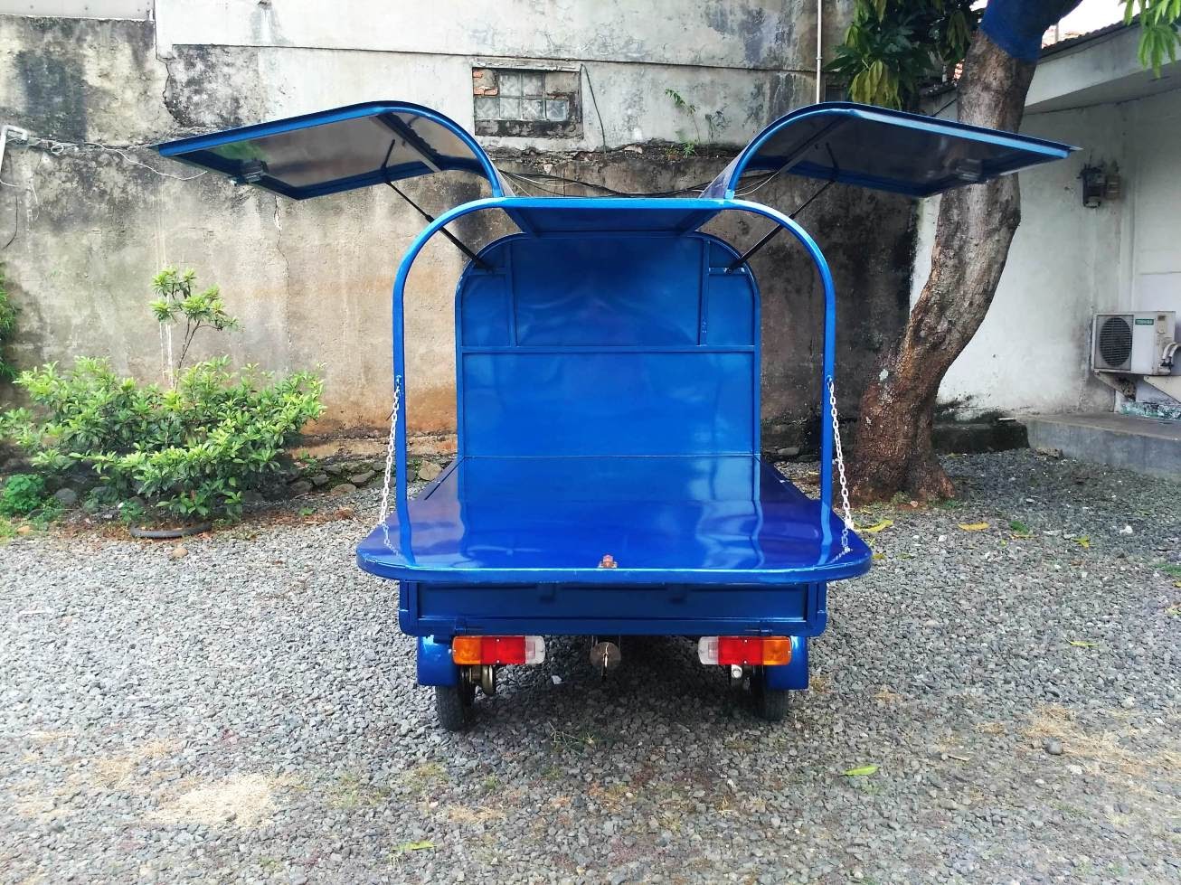 Cargo body with upward-opening doors acting as awnings on Ape Bajaj Wings Box